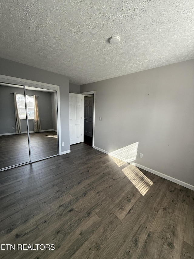 interior space with dark wood-type flooring and a textured ceiling