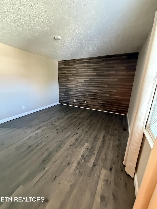 spare room with dark wood-type flooring and a textured ceiling