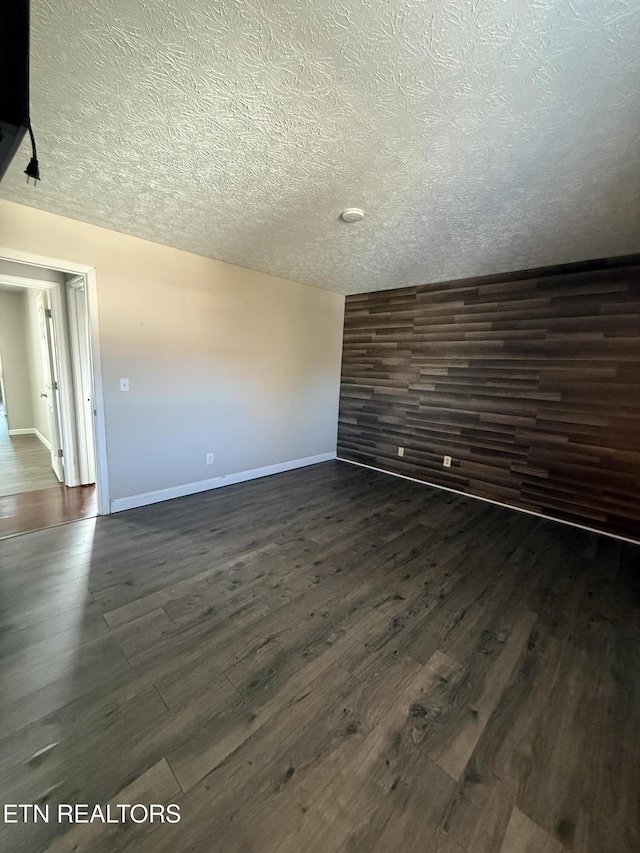 unfurnished room featuring dark hardwood / wood-style floors and a textured ceiling