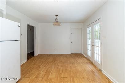 unfurnished dining area with french doors and light hardwood / wood-style floors