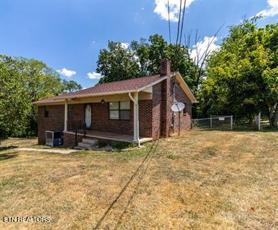 view of property exterior with a lawn and cooling unit