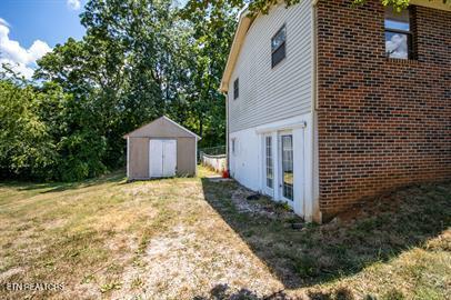 view of home's exterior with a yard and a storage shed