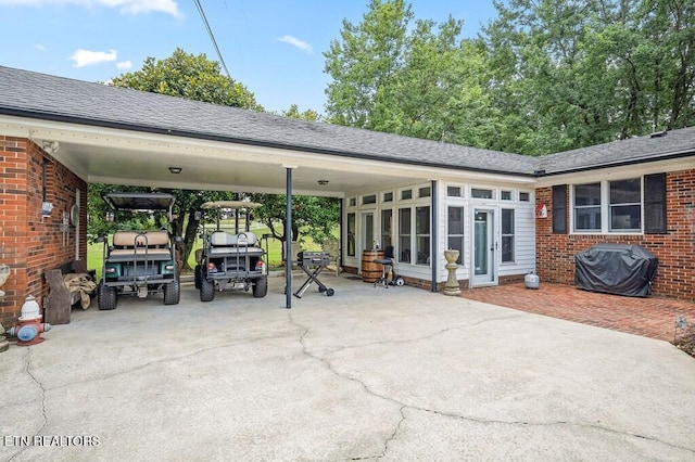 view of patio featuring a sunroom, a carport, and a grill