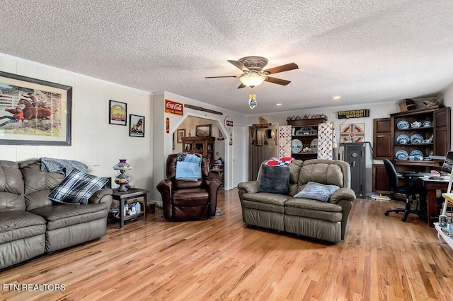 living room featuring a textured ceiling, light hardwood / wood-style floors, and ceiling fan