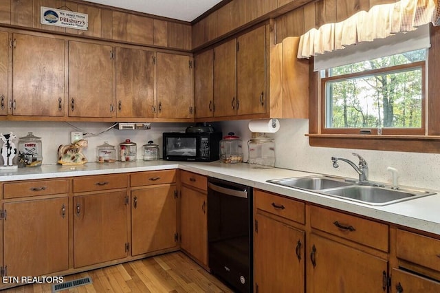 kitchen with backsplash, light hardwood / wood-style flooring, black appliances, and sink