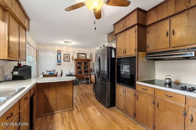 kitchen featuring kitchen peninsula, ceiling fan, black appliances, light hardwood / wood-style floors, and range hood