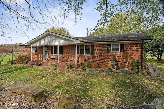 ranch-style house featuring covered porch and a front yard