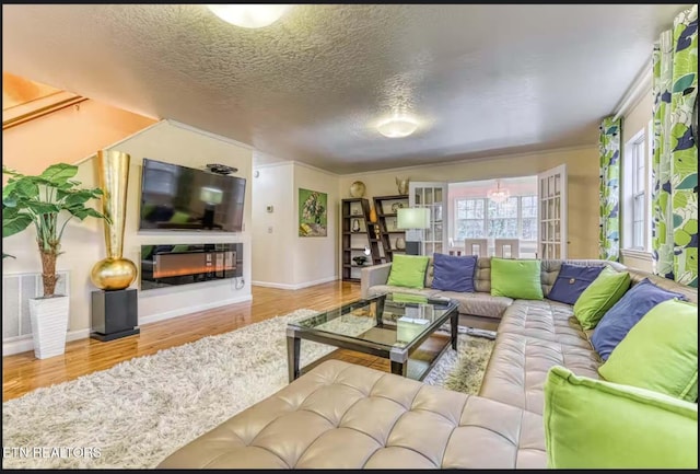 living room with crown molding, a textured ceiling, and hardwood / wood-style flooring