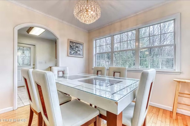 dining room with plenty of natural light, ornamental molding, a chandelier, and light hardwood / wood-style flooring