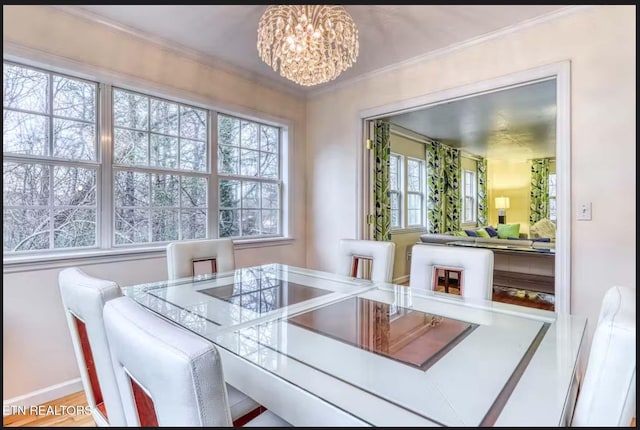 dining area featuring hardwood / wood-style floors, ornamental molding, and an inviting chandelier