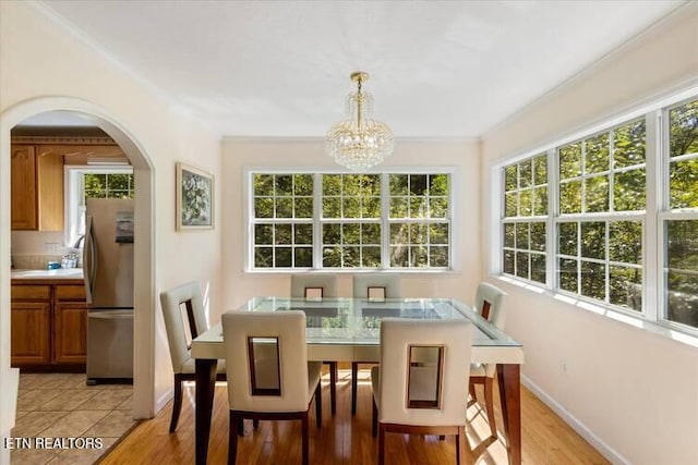 dining area with plenty of natural light, light hardwood / wood-style floors, and an inviting chandelier