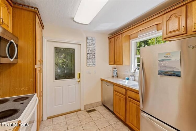 kitchen with sink, light tile patterned floors, and stainless steel appliances