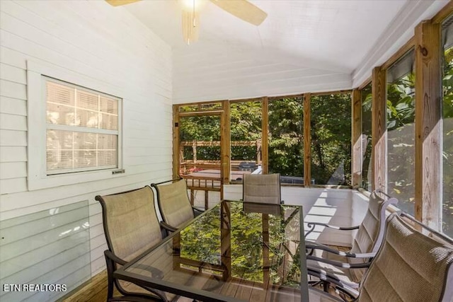 sunroom with ceiling fan, a wealth of natural light, and vaulted ceiling