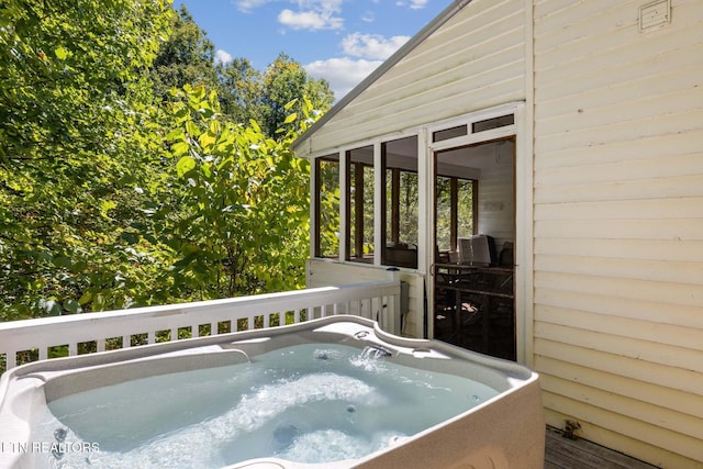 wooden deck featuring a sunroom and a hot tub