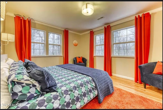 bedroom featuring light wood-type flooring and crown molding