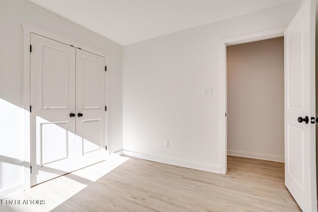 unfurnished bedroom with a closet and light hardwood / wood-style flooring