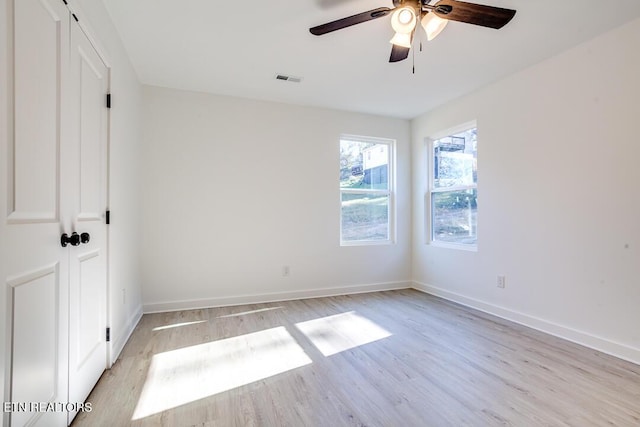 empty room with ceiling fan and light hardwood / wood-style floors