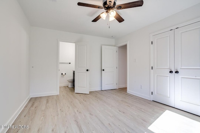 unfurnished bedroom with ceiling fan, light wood-type flooring, connected bathroom, and a closet