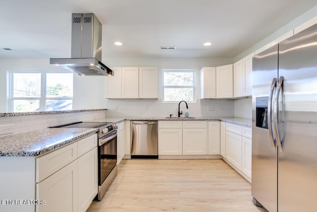 kitchen featuring white cabinets, ventilation hood, stainless steel appliances, and light hardwood / wood-style floors