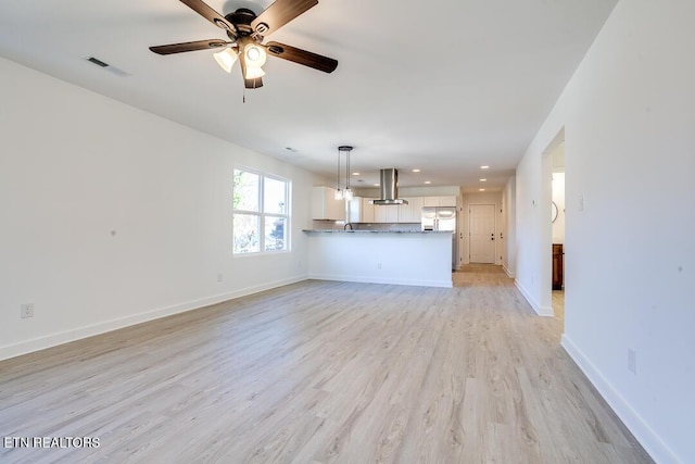 unfurnished living room featuring ceiling fan and light hardwood / wood-style flooring