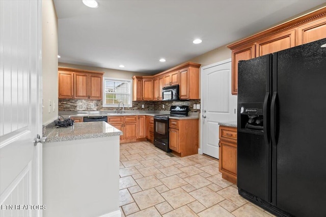 kitchen with decorative backsplash, sink, and black appliances