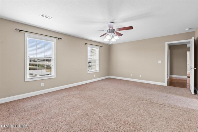 carpeted spare room with plenty of natural light and ceiling fan