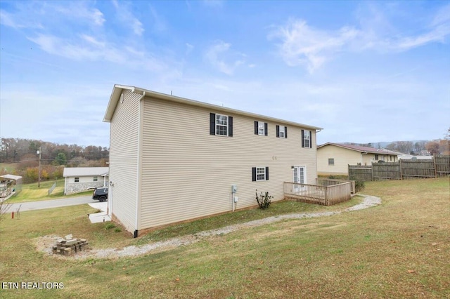 back of house with a lawn and a deck