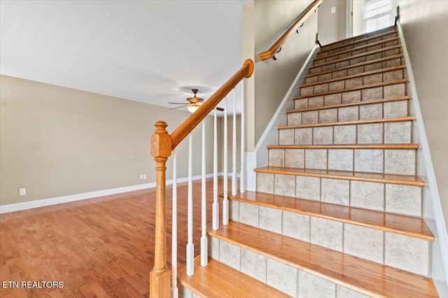 staircase with hardwood / wood-style flooring and ceiling fan