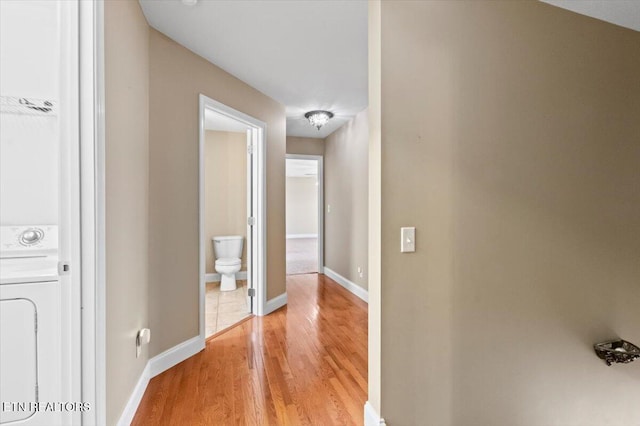 corridor featuring washer / dryer and light wood-type flooring