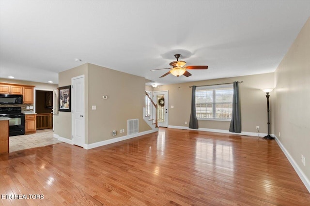 unfurnished living room featuring ceiling fan and light hardwood / wood-style floors