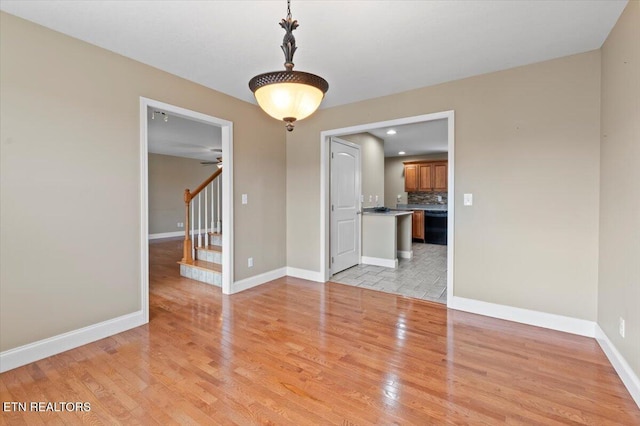 spare room featuring ceiling fan and light hardwood / wood-style flooring