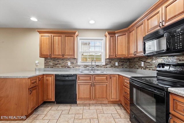 kitchen featuring black appliances, light stone countertops, sink, and tasteful backsplash