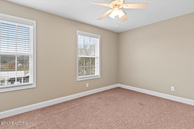 carpeted spare room featuring ceiling fan