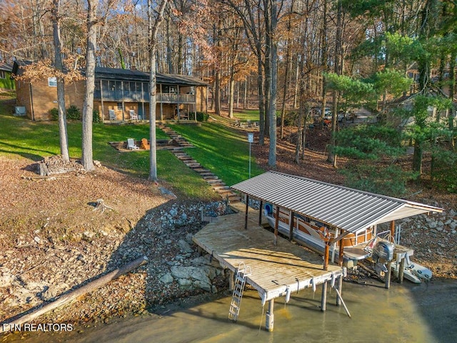 view of dock with a lawn and a water view