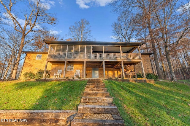 view of front of home with a sunroom and a front yard