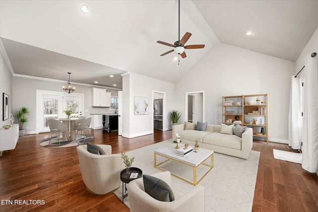 living room featuring ceiling fan with notable chandelier, hardwood / wood-style flooring, high vaulted ceiling, and ornamental molding