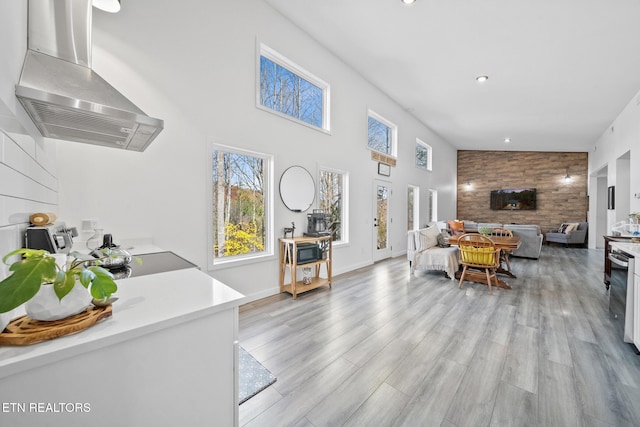 living room with high vaulted ceiling, light hardwood / wood-style flooring, and wooden walls