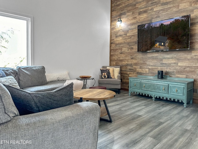 living room featuring light hardwood / wood-style flooring and wood walls