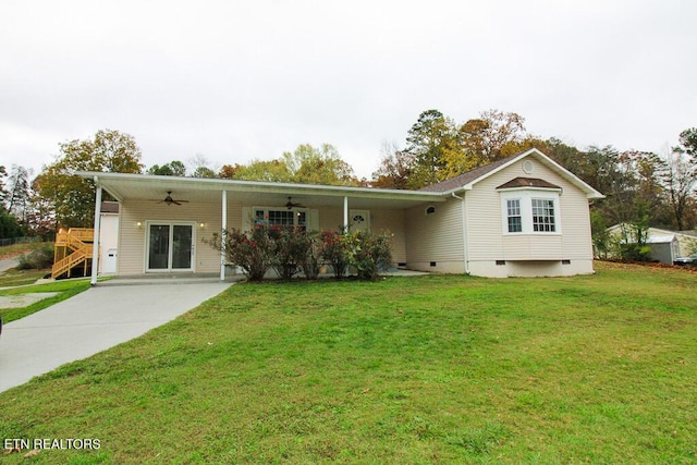 back of house with a carport, ceiling fan, and a lawn