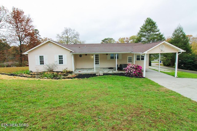 ranch-style home with covered porch, a carport, cooling unit, and a front yard