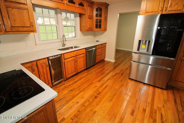 kitchen featuring stainless steel appliances, wine cooler, light hardwood / wood-style floors, and sink