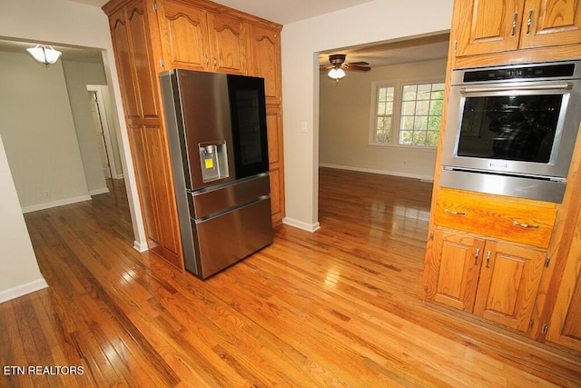 kitchen featuring ceiling fan, appliances with stainless steel finishes, and light hardwood / wood-style flooring