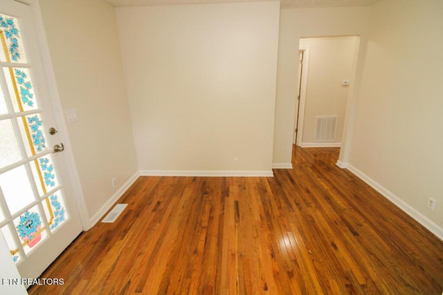 empty room with plenty of natural light and dark wood-type flooring