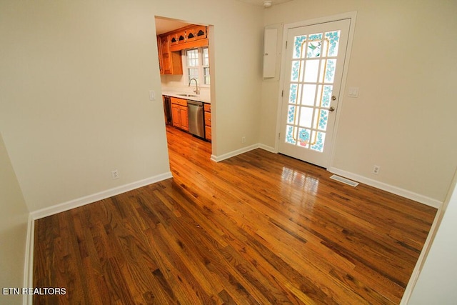 unfurnished room featuring hardwood / wood-style floors and sink