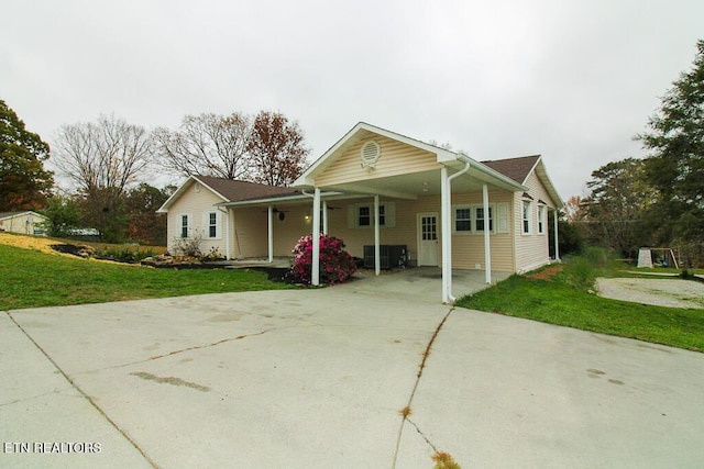 view of front of property featuring a front lawn, central AC unit, and a carport