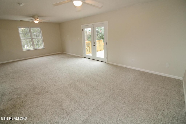 spare room with light carpet, french doors, and ceiling fan