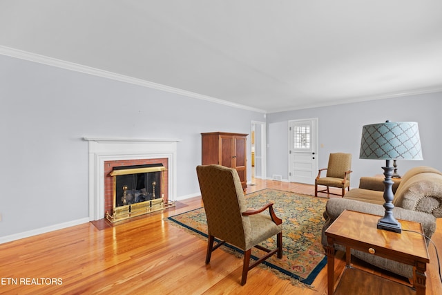 living room featuring a brick fireplace, wood-type flooring, and ornamental molding