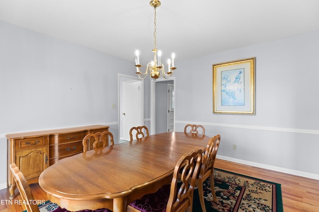 dining area featuring light wood-type flooring and a chandelier