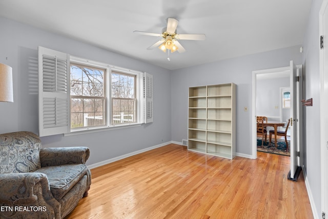 living area featuring ceiling fan and light hardwood / wood-style floors