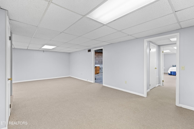 basement with a drop ceiling and light carpet